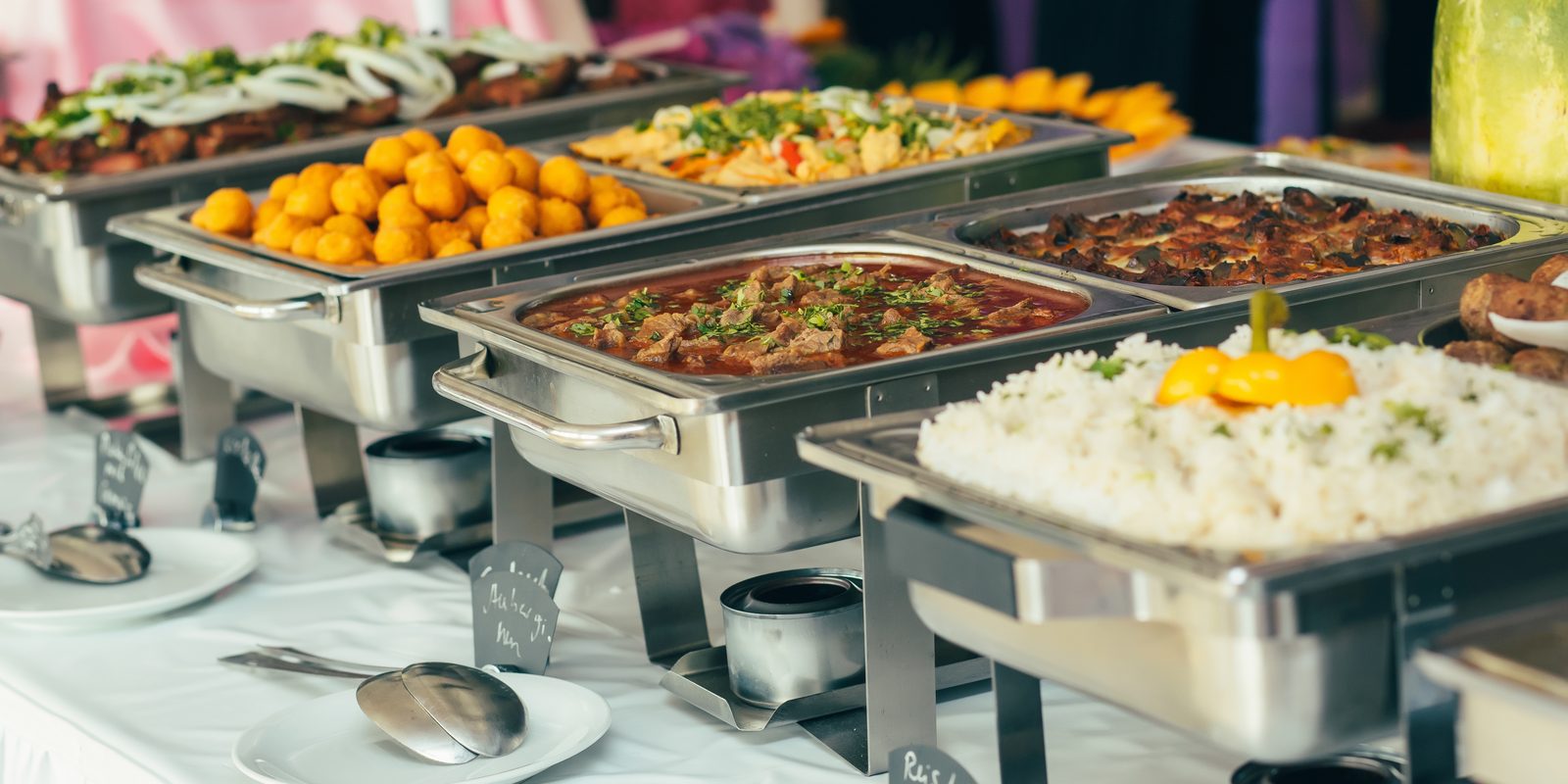 A generous catered spread of mains, rice, and sides in chafing dishes